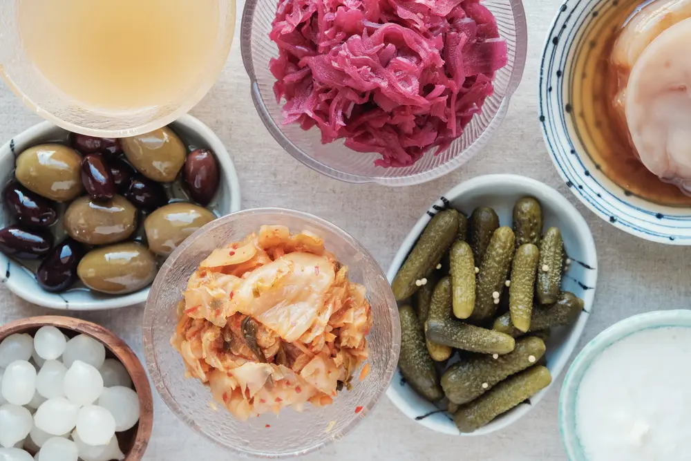 Układ kimchi, kiszonej kapusty, ogórków, oliwek i jogurtu.