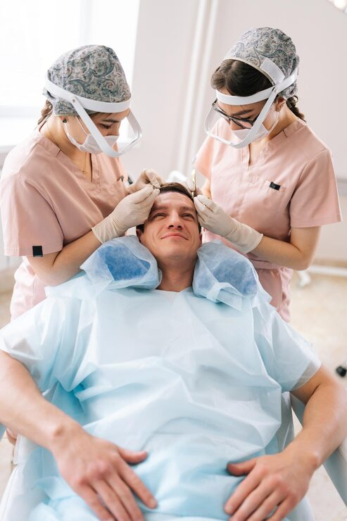 Zabieg przeszczepu włosów w Turkus Hair Transplant Clinic: dwóch specjalistów implantuje grafty u pacjenta na fotelu medycznym.